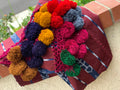 Foot loomed blanket with pom poms